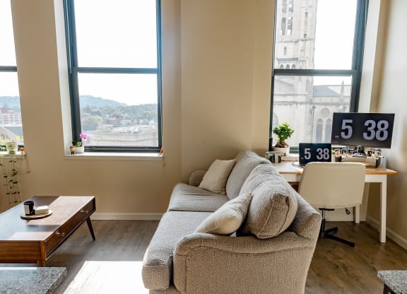 a living room with a couch and a table in front of a window at Walnut on Highland, Pittsburgh, PA