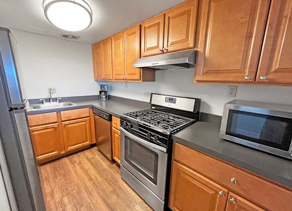 A kitchen with wooden cabinets and stainless steel appliances at Walnut Towers at Frick Park, Pittsburgh, 15217
