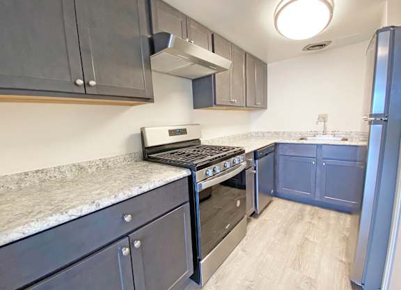 A kitchen with a stove top oven and a refrigerator at Walnut Towers at Frick Park, Pennsylvania