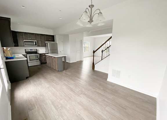 A spacious kitchen with a staircase leading to the upper floor. at Highland Village, Ross Township, Pittsburgh, PA 15229