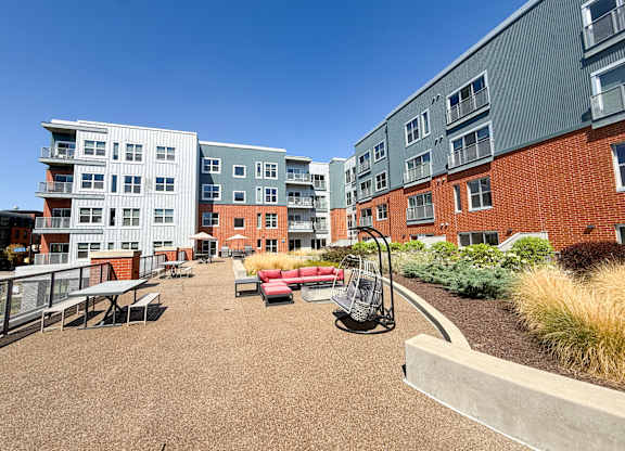 A playground area with a slide and seating area in front of apartment buildings. Hot Metal Flats apartments, Southside Pittsburgh, PA