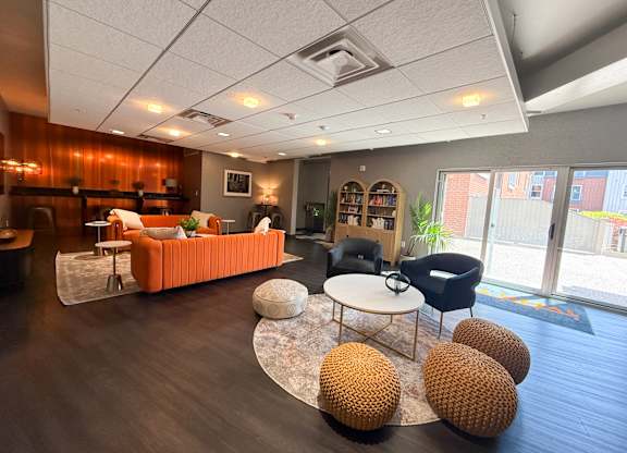 Lounge room with a sofa, chairs, and a coffee table. Hot Metal Flats apartments, Southside Pittsburgh, PA