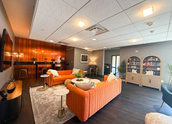 A living room with a sofa, a table, and a bookshelf. Hot Metal Flats apartments, Southside Pittsburgh, PA