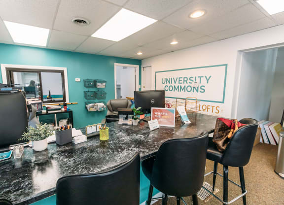 an office with a long desk with black chairs and a sign that says university commons at University Commons Apartments, Oakland, Pittsburgh