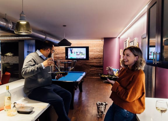 a man and a woman in a room with a pool table and tv at Walnut on Highland, Pittsburgh, PA