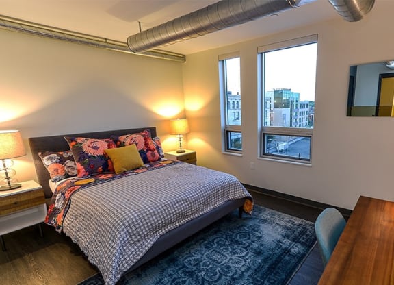 a bedroom with a bed and a desk with two lamps at Walnut on Highland, Pittsburgh, PA
