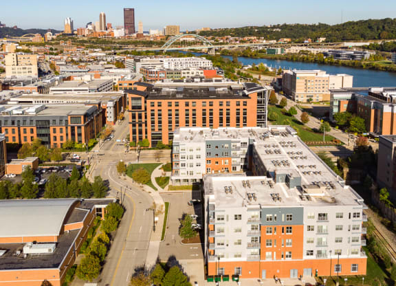 a cityscape with a river and a city in the background Hot Metal Flats apartments, Southside Pittsburgh, PA