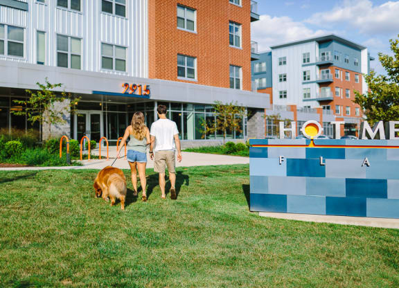 a man and a woman walking a dog in front of a building Hot Metal Flats apartments, Southside Pittsburgh, PA
