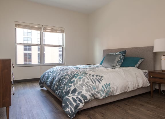 a bedroom with a bed and two windows Hot Metal Flats apartments, Southside Pittsburgh, PA