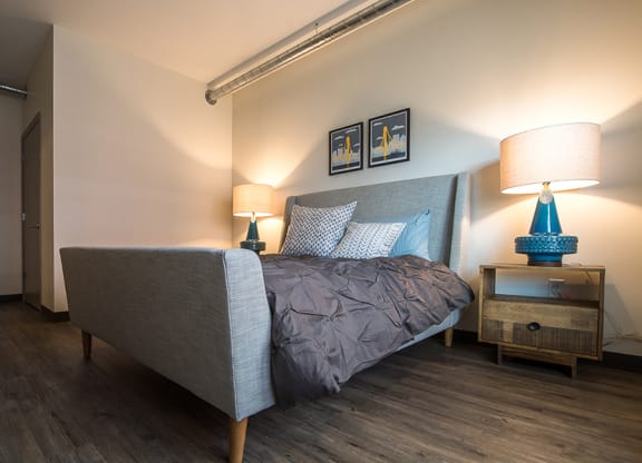 a bedroom with a bed and two lamps Hot Metal Flats apartments, Southside Pittsburgh, PA