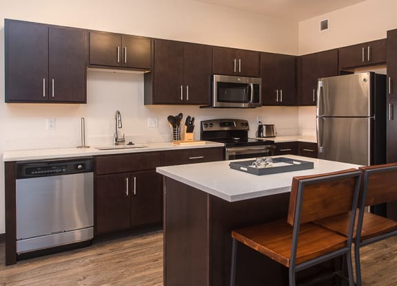 a kitchen with dark cabinets and white countertops Hot Metal Flats apartments, Southside Pittsburgh, PA