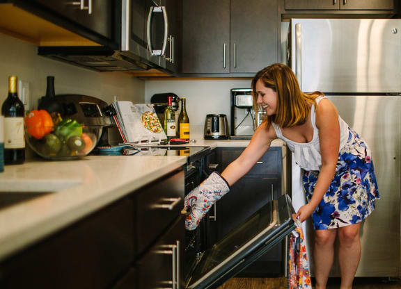 a woman putting an oven mitt in the oven Hot Metal Flats apartments, Southside Pittsburgh, PA