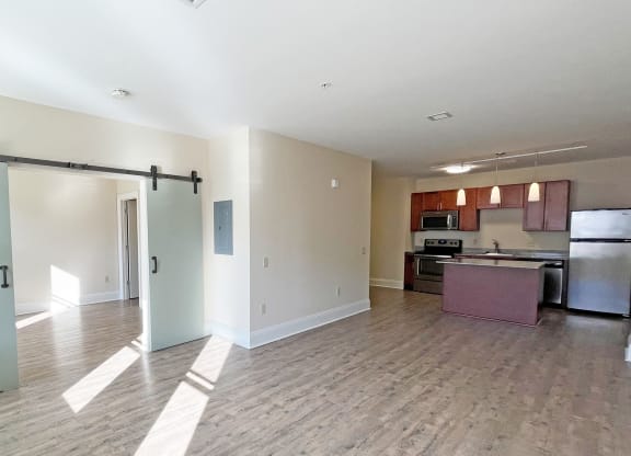 an open living room and kitchen area with a sliding barn door at Walnut on Highland, Pittsburgh, PA