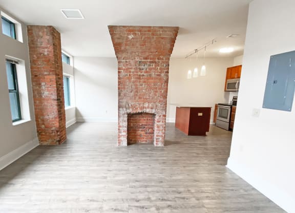 a living room with a fireplace and a kitchen in the background at Walnut on Highland, Pittsburgh, PA