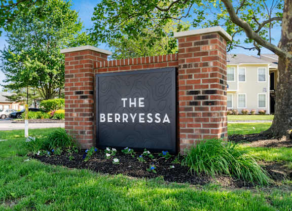 A sign that says "The Berryessa" is mounted on a brick wall.