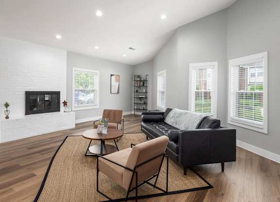 A living room with a black couch, a chair, and a coffee table.