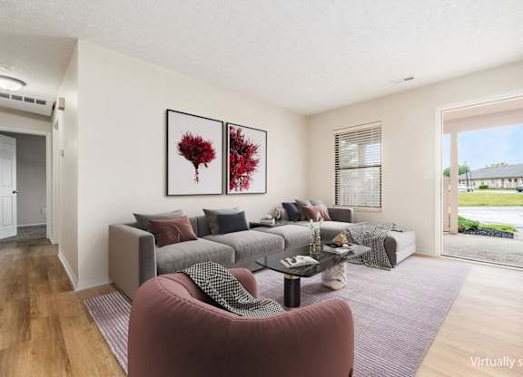 A living room with a grey couch and a red armchair.