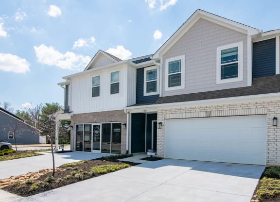 a house with a garage door and a driveway at Jackson Run Townhomes, Whitestown, IN 46075