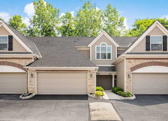 A house with a grey roof and two garages. at River View at Bexley Apartments, River View at Bexley