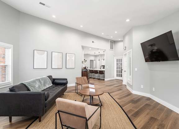A living room with a grey couch and a wooden floor.