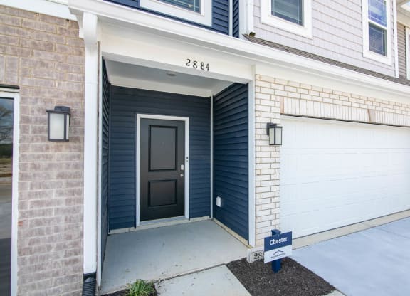 a front door of a house with two garage doors at Jackson Run Townhomes, Whitestown Indiana
