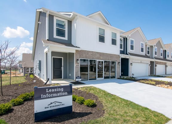 a building with a leasing information sign in front of it at Jackson Run Townhomes, Whitestown, 46075
