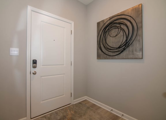 a bedroom with a white door and a painting on the wall at Jackson Run Townhomes, Whitestown, IN