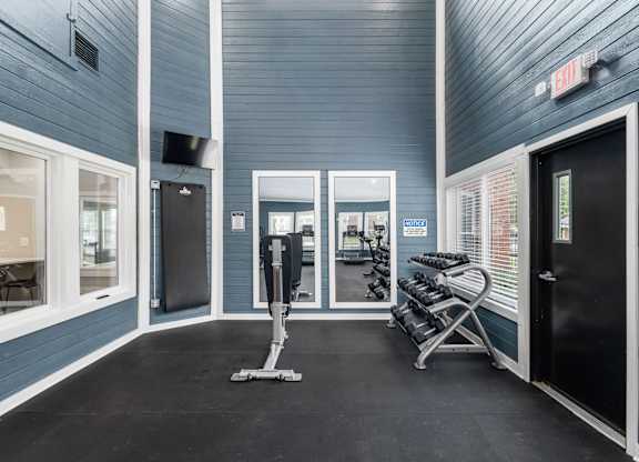 A gym with a blue wall and a treadmill.
