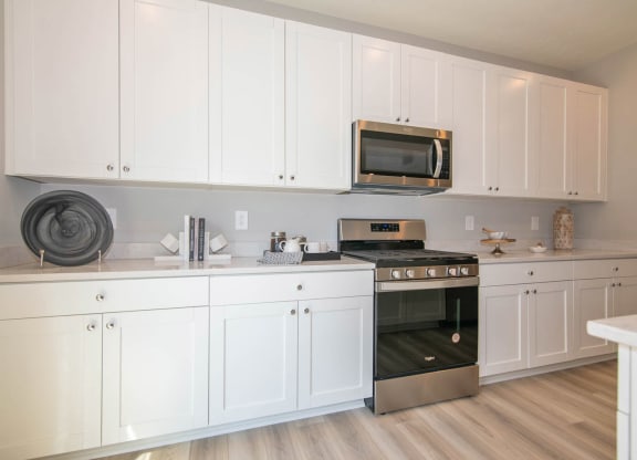a kitchen with white cabinets and a stove top oven at Jackson Run Townhomes, Indiana