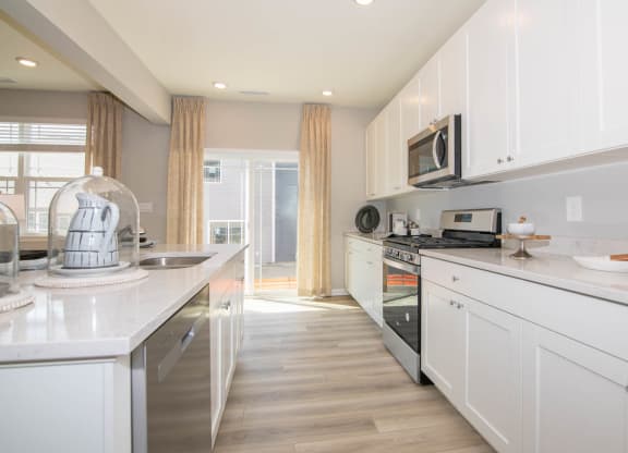 a kitchen with white cabinets and a counter top at Jackson Run Townhomes, Indiana