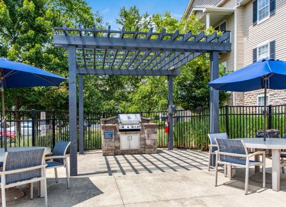 our patio has a grill and tables with umbrellas
