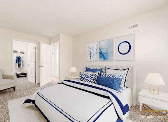 A bedroom with a large bed and a chair.