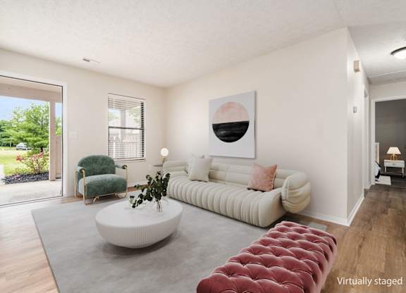 A living room with a white couch and a green chair.
