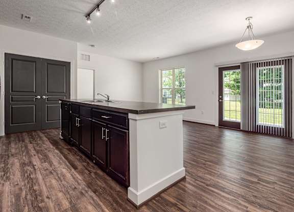 A kitchen with dark wood cabinets and a white island. at River View at Bexley Apartments, River View at Bexley, OH, 43209