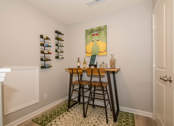 a bar with three stools in a room with a door and a wall with at Jackson Run Townhomes, Indiana