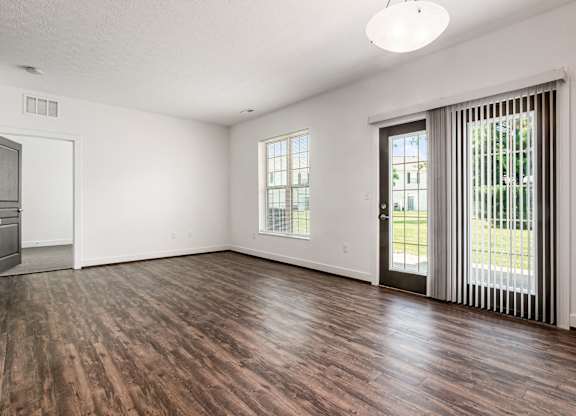 A room with wooden flooring and a sliding glass door. at River View at Bexley Apartments, River View at Bexley, OH
