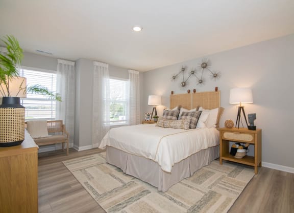a bedroom with a bed and two windows at Jackson Run Townhomes, Whitestown, IN
