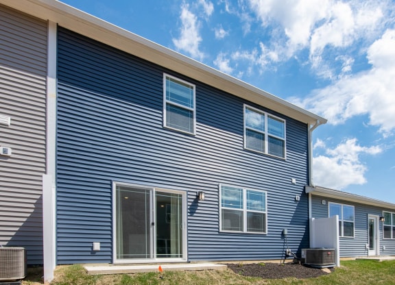 the exterior of a blue house with a cloudy sky in the background at Jackson Run Townhomes, Whitestown, IN