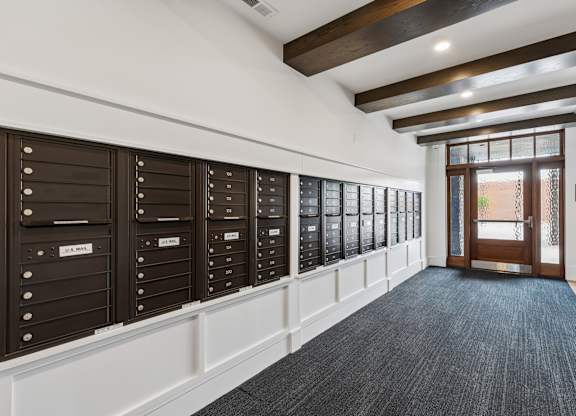 A hallway with a row of mailboxes on the wall.