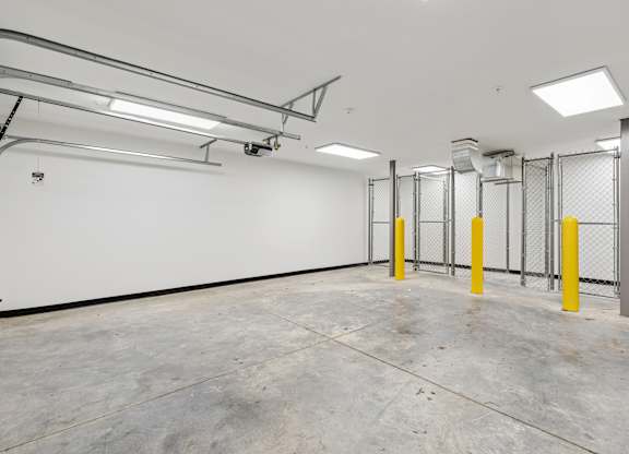 A large, empty room with a concrete floor and white walls.
