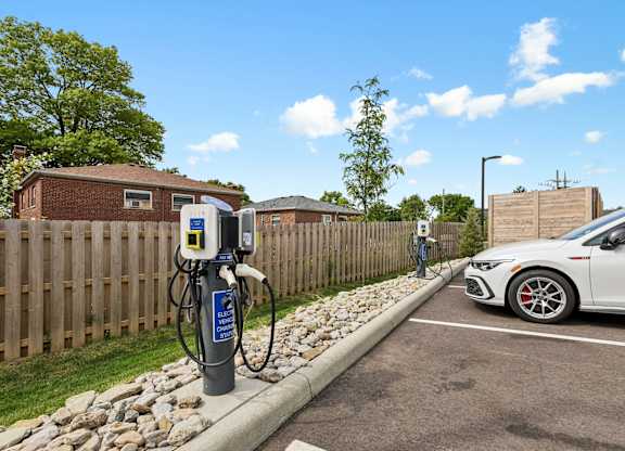 A white car is parked next to a charging station.