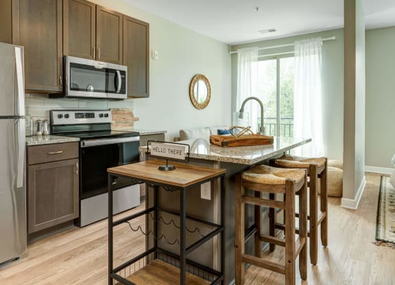 a kitchen with an island with wooden stools at Adelphi Quarter, Columbus