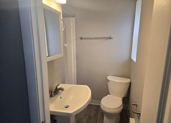 A white toilet sits next to a sink in a small bathroom.