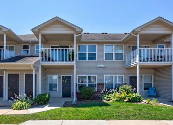 A row of houses with balconies and front yards.