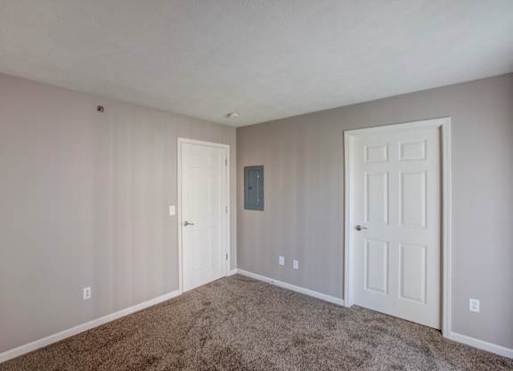 A room with two doors and a carpeted floor.