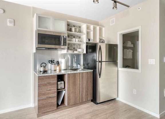 A kitchen with a refrigerator, microwave, and oven.at Sky Central, Cincinnati