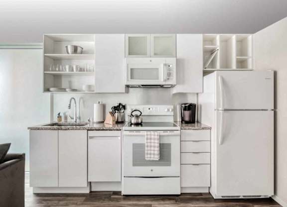 A white kitchen with a refrigerator, oven, and microwave.at Sky Central, Cincinnati, OH 45202