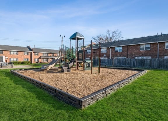 a playground with a swing set in the middle of a grassy area