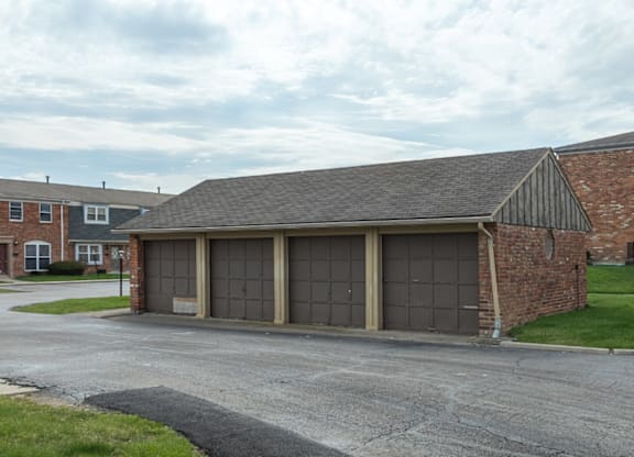 A garage with a brick wall and a grey roof.
