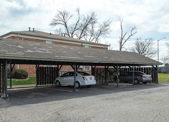 A parking lot with a building and cars.